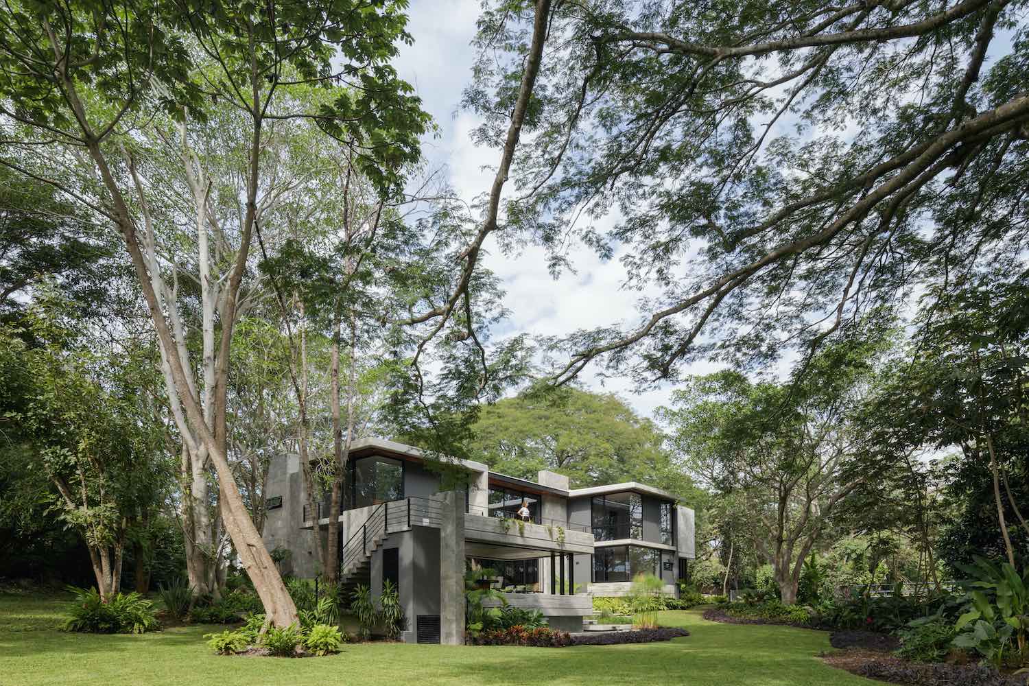 a concrete house located among trees in a jungle in Mexico 