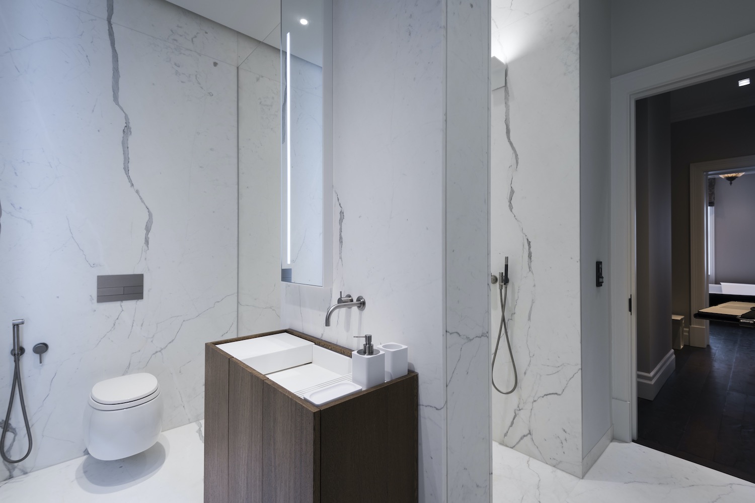 toilet with marble stone walls and washing basin